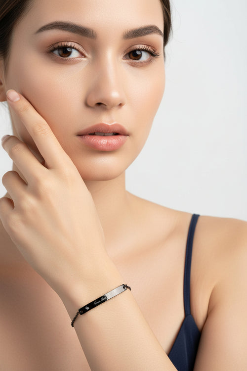 Black chain bracelet with engraved text on a white background